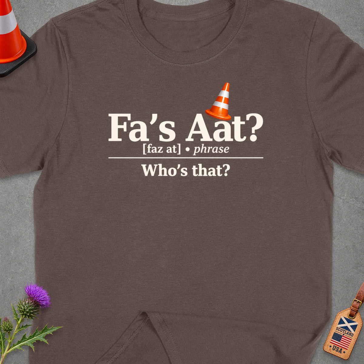 Brown t-shirt with "Fa's Aat? Who's that?" text and traffic cone.