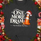 Dark t-shirt with "ONE MORE DRAM" text, traffic cone, whisky glass, and festive decorations.