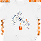 White t-shirt with "You say Soccer, I say Football" graphic and a traffic cone.