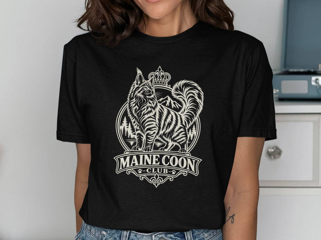 Black t-shirt with a cream graphic of a Maine Coon cat wearing a crown and "MAINE COON CLUB" text.