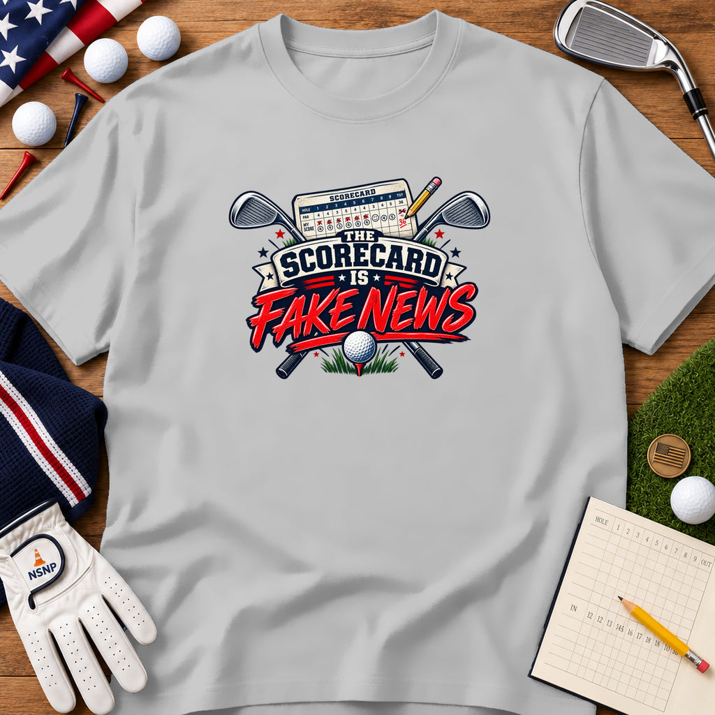 Light gray t-shirt featuring a golf graphic with crossed clubs, scorecard, ball, and the text The Scorecard is Fake News.