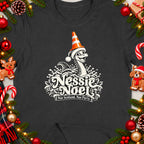 Dark t-shirt with Nessie wearing a Santa hat and traffic cone, "Nessie Noel" text.