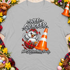 T-shirt graphic with chick hatching from plaid egg, traffic cone, and text "Wee Cracker".