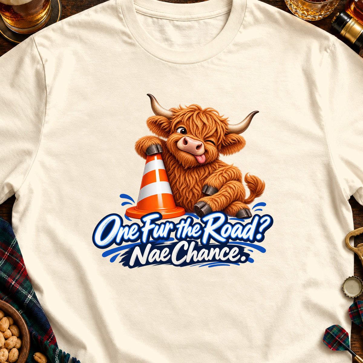 Fluffy Highland cow with a traffic cone and text "One Fur the Road? Nae Chance."