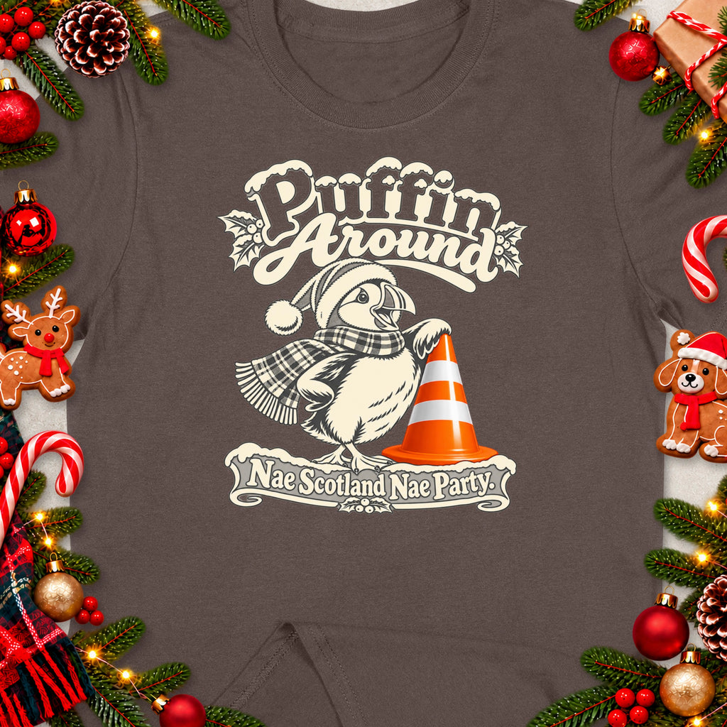 T-shirt design with a puffin in a Santa hat and scarf, standing near a traffic cone.
