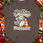 T-shirt design with a puffin in a Santa hat and scarf, standing near a traffic cone.