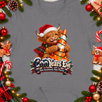 Highland cow with Christmas lights on traffic cone and text "CooYears Eve Nae Scotland, Nae Party".