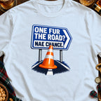 Blue sign with text "ONE FUR THE ROAD? NAE CHANCE." above an orange traffic cone.