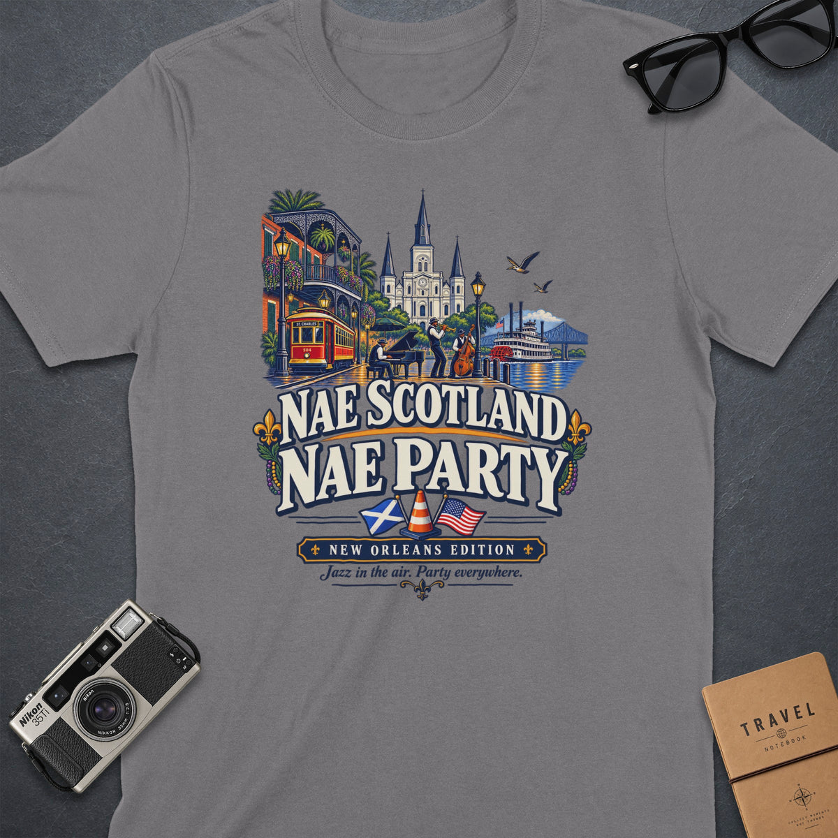 T-shirt graphic: New Orleans scene with trolley, musicians, paddleboat, and text "Nae Scotland Nae Party".