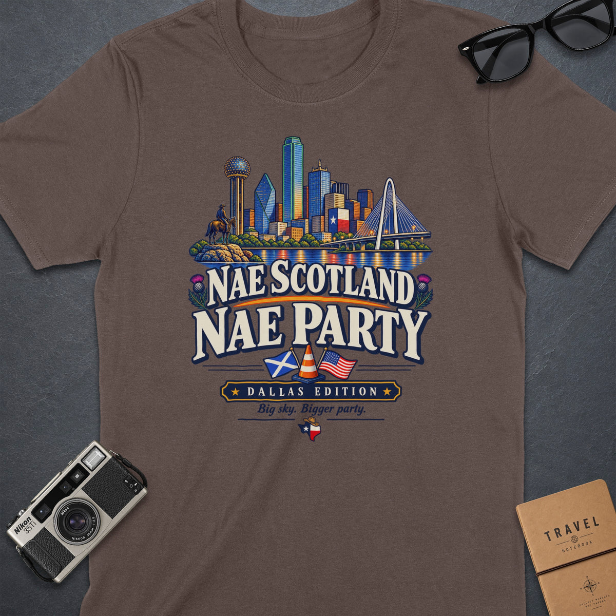 Brown t-shirt graphic featuring Dallas skyline, "Nae Scotland Nae Party," and "Dallas Edition."