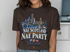 Brown t-shirt with Austin skyline, text "NAE SCOTLAND NAE PARTY", flags, and tagline.