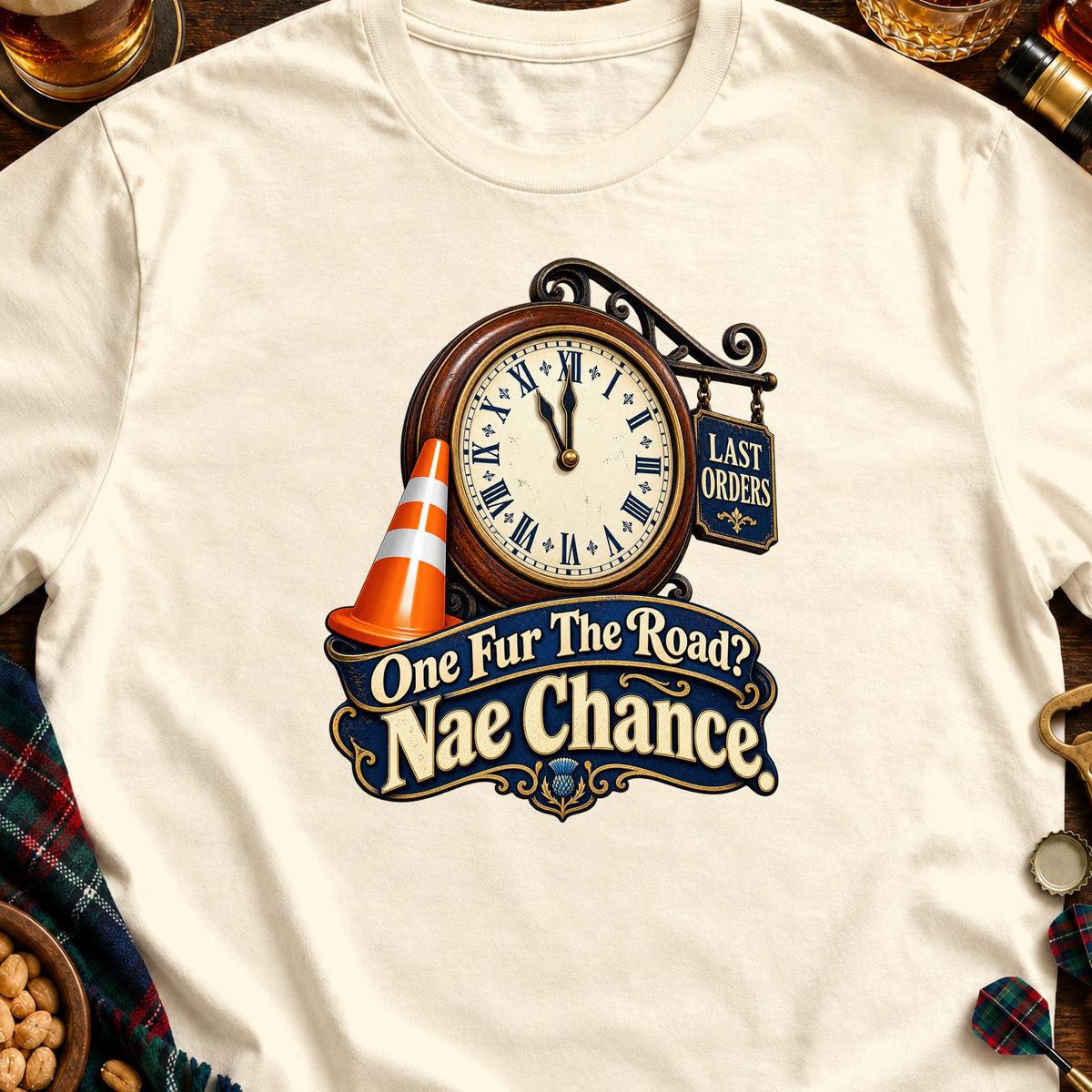 Cream t-shirt with a graphic of a clock, traffic cone, and text "One Fur The Road? Nae Chance".