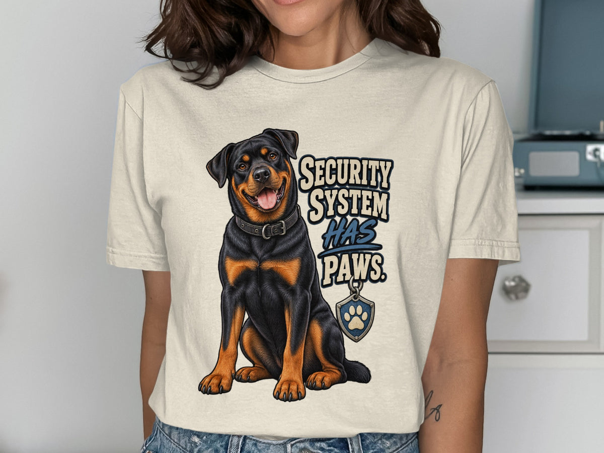 Rottweiler graphic with text "SECURITY SYSTEM HAS PAWS" on a t-shirt.