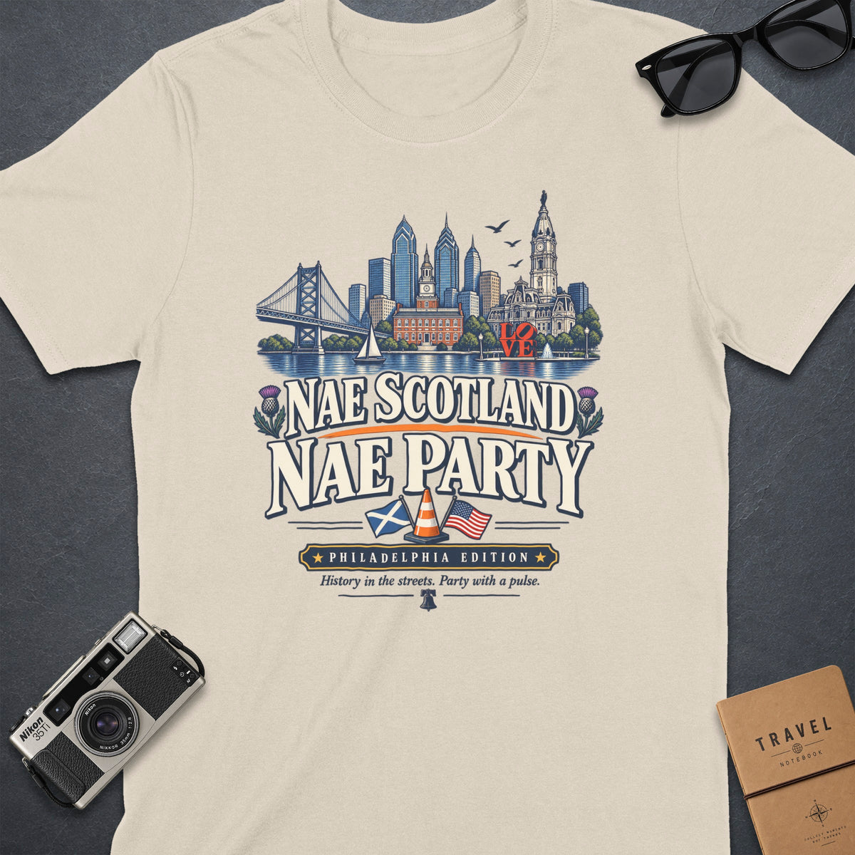 Cream t-shirt with "Nae Scotland Nae Party Philadelphia Edition" text and skyline graphic.