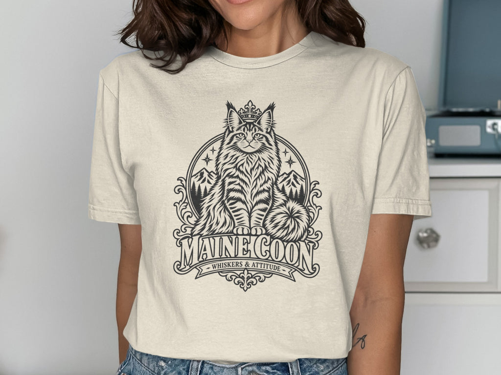 Maine Coon cat wearing a crown, with mountains and stars, text reads "MAINE COON WHISKERS & ATTITUDE".