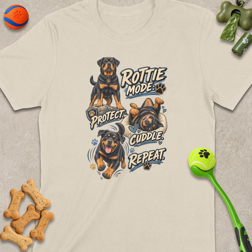 Rottie Mode: Protect, Cuddle, Repeat graphic on a cream t-shirt with dog toys.